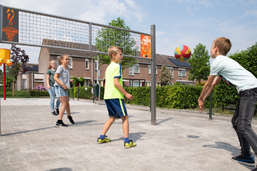 Kinderen die volleyballen op een netsportcourt
